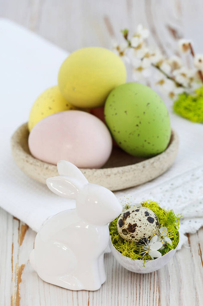 Easter table decoration with colorful eggs and ceramic  rabit figurine. Festive decor - Fotoğraf, Görsel