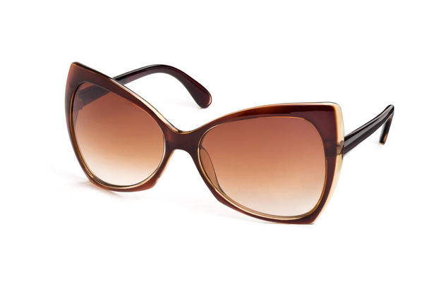 Stylish women`s sunglasses with a brown plastic frame and orange gradient lenses isolated on a white background. Half a turn. - Foto, afbeelding