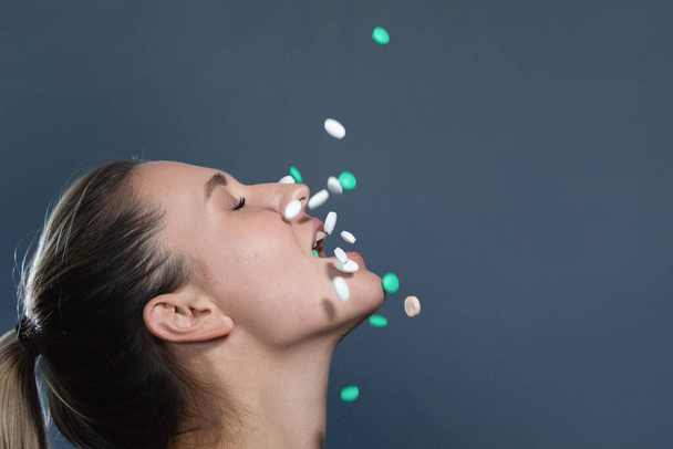 Une épidémie de Covid-19. Femme attrape une dispersion de comprimés dans sa bouche et les mange. - Photo, image