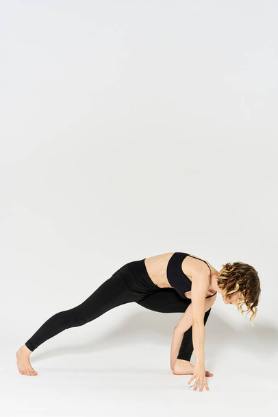 Femme en vêtements de sport est engagé dans la gymnastique d'intérieur fitness silhouette mince - Photo, image