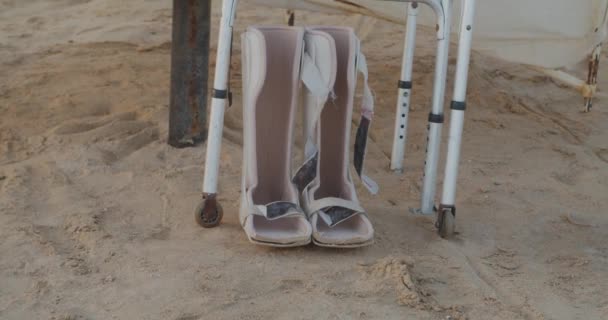 Gehandicapte wandeluitrusting onder paraplu op het strand - Video