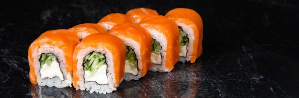 Ensemble de rouleaux japonais de saumon et de riz sushi sur un fond noir de marbre avec des fils. Bunner pour le web. - Photo, image