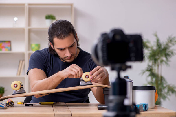 Young male skateboarder repairman recording video for his blog - Foto, Bild
