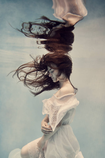         A girl in a dress underwater seems to fly in weightlessness                        - Foto, Imagem