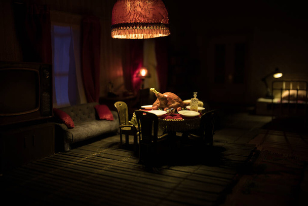 Conceito criativo feriado de ação de graças. Uma sala de estar de casa de bonecas realista com móveis e janela à noite. Ação de Graças Turquia miniatura na mesa. Foco seletivo - Foto, Imagem