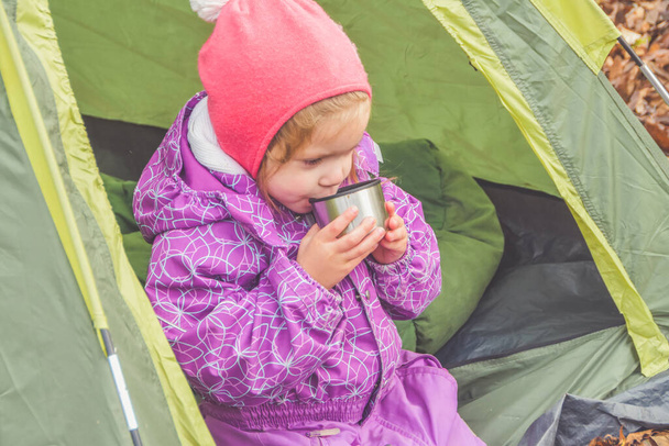 the on an autumn day a child is having Breakfast in a tent at a campsite - Foto, Imagem