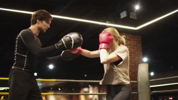 Boze sport vrouw training met coach in de sportschool. fit meisje vechten op boksen ring - Video