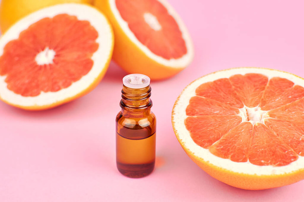 Citrus pure essential oil in dark glass bottle on pink background, aromatherapy or alternative medicine treatment. - Fotó, kép