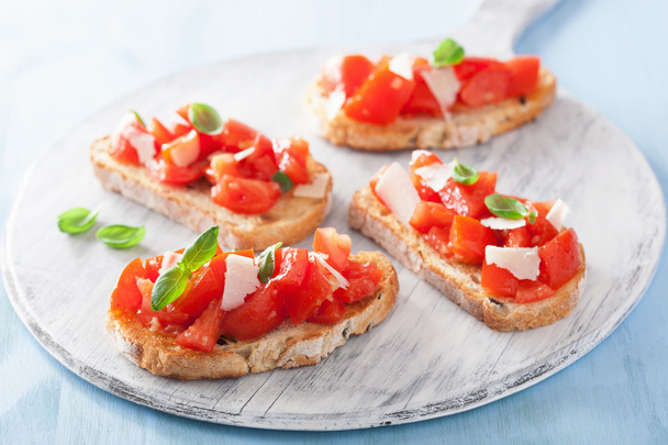 Italian bruschetta with tomatoes, parmesan, garlic and olive oil - Photo, Image