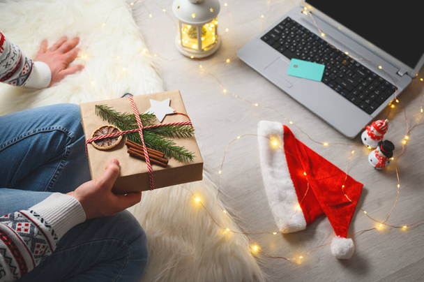Vue du dessus de l'homme faisant du shopping en ligne pendant les vacances de Noël tenant un cadeau. Achats en ligne Noël - Photo, image