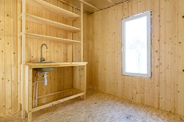 Malá kuchyňka v interiéru místnosti nového rámu venkovského domu - Fotografie, Obrázek