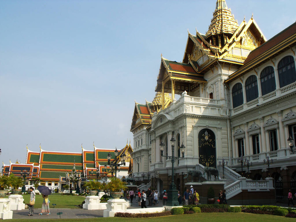 Bangkok, Tailandia, 25 de enero de 2013: Visitantes en el jardín junto a un edificio en el Palacio Real de Bangkok - Foto, imagen