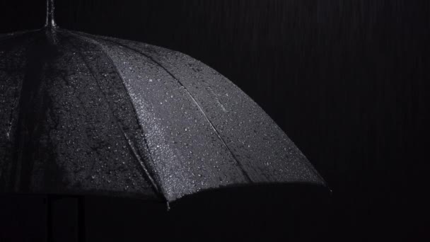 Съемки черного зонта и дождевых капель на черном фоне - Кадры, видео