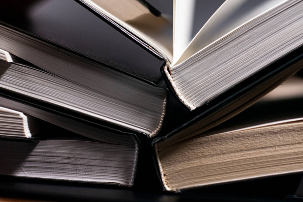 Open books are arranged in an overlapping way. Vertical position. Closeup. - Photo, Image