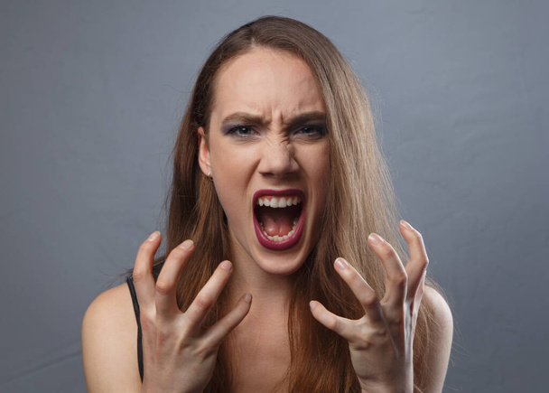 Photo of screaming girl with bright make-up on grey background - Zdjęcie, obraz