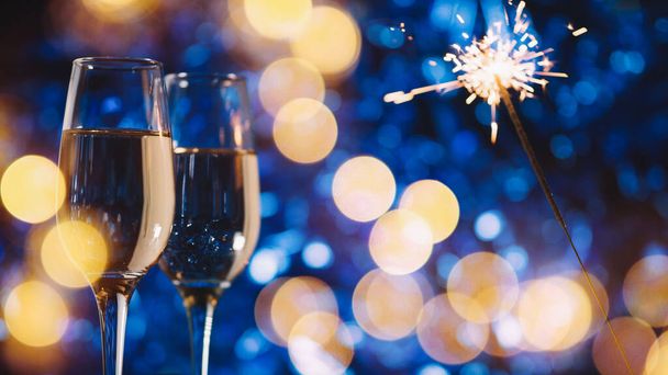 Kaksi lasia samppanjaa sinisellä pohjalla. Hyvää joulua ja onnellista uutta vuotta - Valokuva, kuva