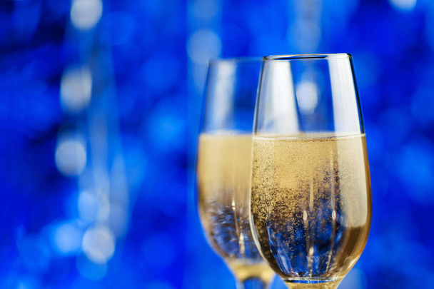 Dvě sklenice šampaňského na modrém pozadí. Veselé Vánoce a šťastný nový rok - Fotografie, Obrázek