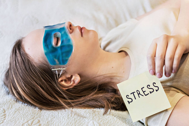 Junge Frau entspannt sich mit einer kühlenden Gel-Augenmaske auf dem Gesicht. Das Konzept der psychischen Probleme und Stress. - Foto, Bild