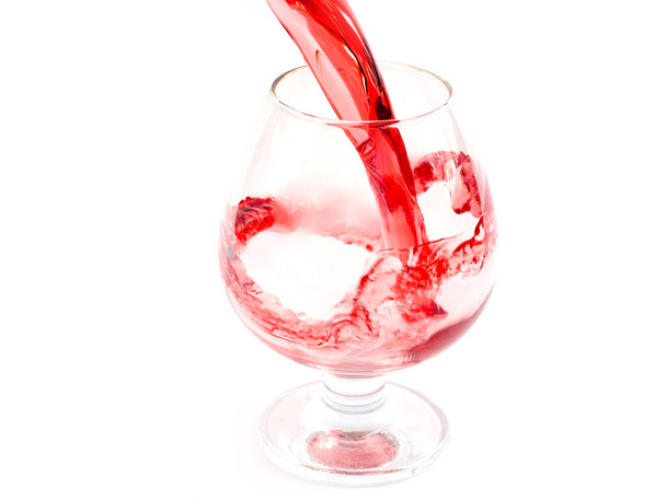 fancy patterns of red wine when pouring it into a glass wineglass - Fotó, kép