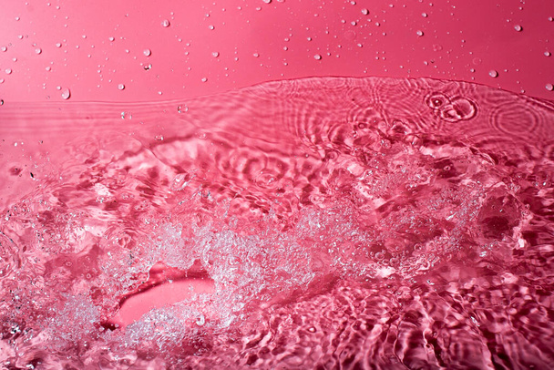 splash of water on a red background. Abstract wallpaper - 写真・画像