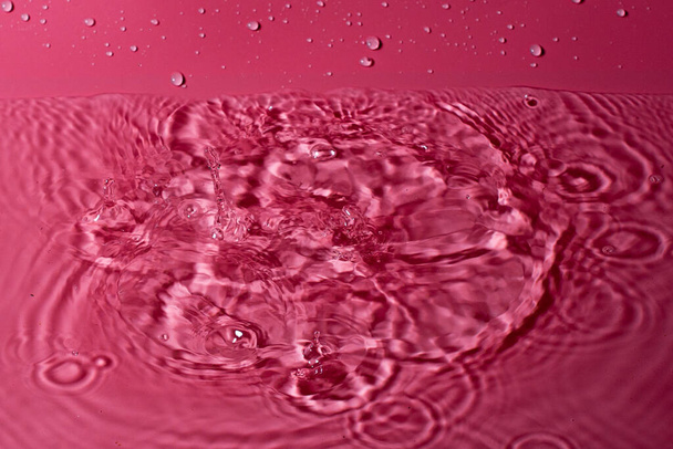 splash of water on a red background. Abstract wallpaper - Fotografie, Obrázek