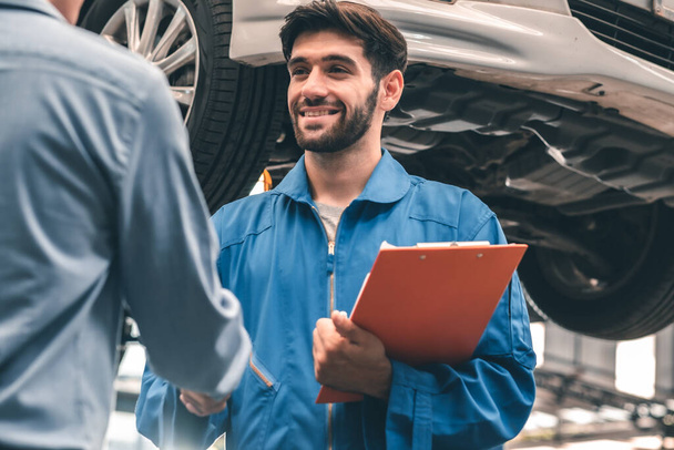 Car Mechanic Ready For Work. Auto Mechanic with Large Wrench in Hands. Ideas How to Fix the Problem.Male mechanics at the garage fixing a car.Closed up focus . - Foto, imagen