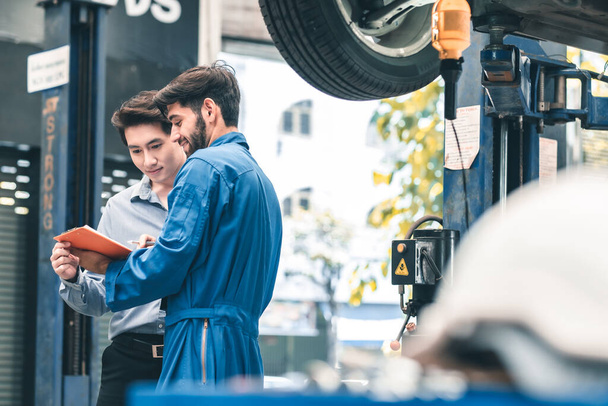 Car Mechanic Ready For Work. Auto Mechanic with Large Wrench in Hands. Ideas How to Fix the Problem.Male mechanics at the garage fixing a car.Closed up focus . - Foto, immagini
