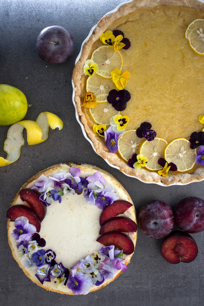 Yenilebilir çiçeklerle süslenmiş limonlu tart ve peynirli kek. Güzel yemek manzaralı fotoğraf. Tatil menüsü fikirleri.  - Fotoğraf, Görsel