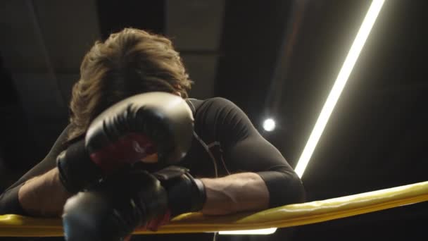 Müder Boxer macht Pause nach Kampf im Fitnessstudio. Fitter Mann beim Ausruhen im Sportverein - Filmmaterial, Video