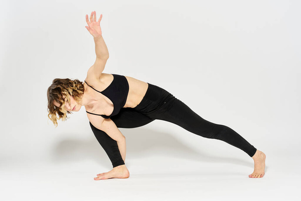 Vrouw in sportkleding houdt zich bezig met fitness indoor gymnastiek slank figuur - Foto, afbeelding