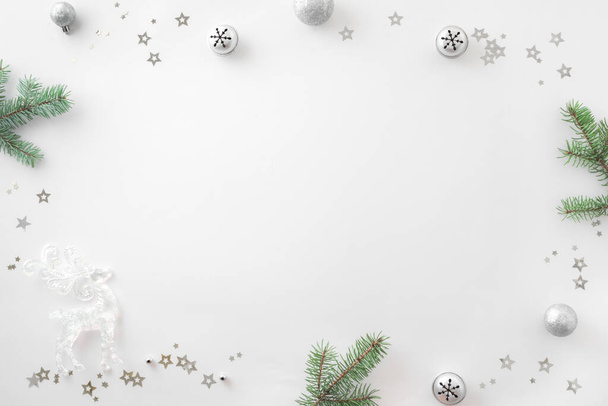 Christmas composition. Christmas decor, pine brances, silver confetti on white background. Top view, copy space. - Фото, зображення