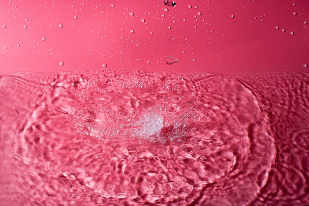 splash of water on a red background. Abstract wallpaper - Photo, image