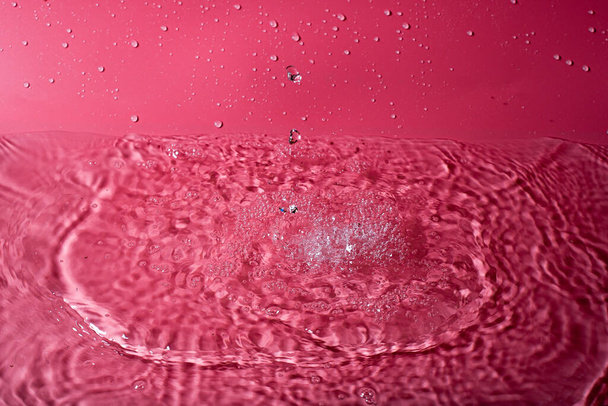 splash of water on a red background. Abstract wallpaper - Zdjęcie, obraz