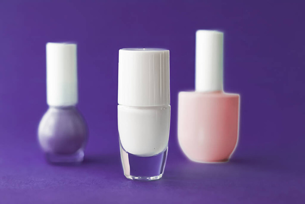 Nagellackflaschen auf dunkelviolettem Hintergrund, Beauty-Marke - Foto, Bild