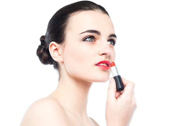 Beautiful woman applying a lipstick - Photo, image