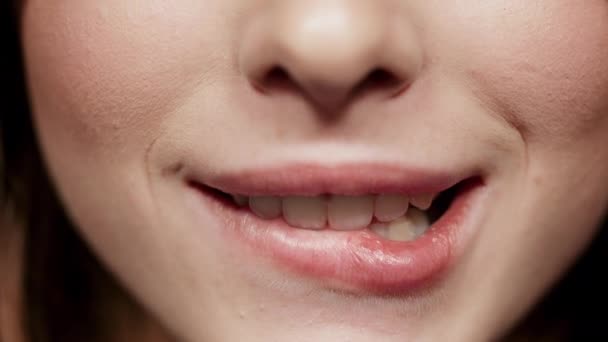 Verspieltes Mädchen beißt Lippe im Studio. Charmanter Frauenmund, der drinnen lächelt - Filmmaterial, Video