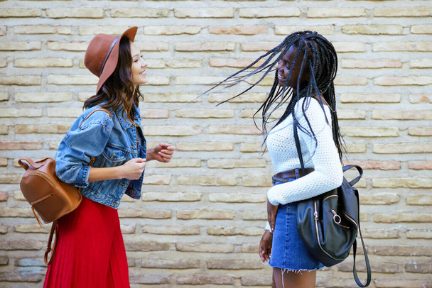 Two female friends having fun together on the street. Multiethnic friends. - Fotoğraf, Görsel