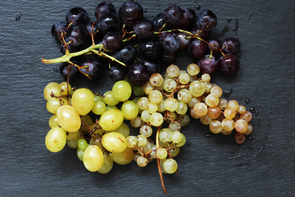 Fotografia trzech pęczków winogron na łupkach do ilustracji żywności - Zdjęcie, obraz