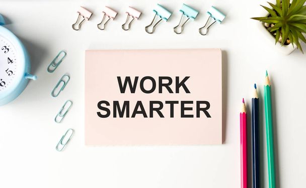 WORK SMARTER text written on a notebook with pencils and graphs. - Фото, изображение