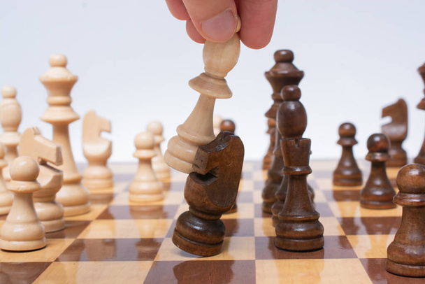 Mão fazendo movimento no tabuleiro de xadrez como estratégia e conceito de liderança - Foto, Imagem