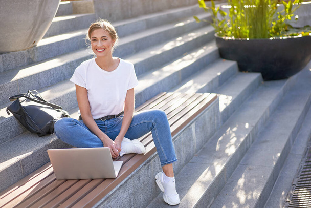 Businesswoman sitting stairs summer park using laptop Business person working remote. Outdoor Successful european caucasian woman freelancer make video call teacher study work online lessons  - Фото, зображення