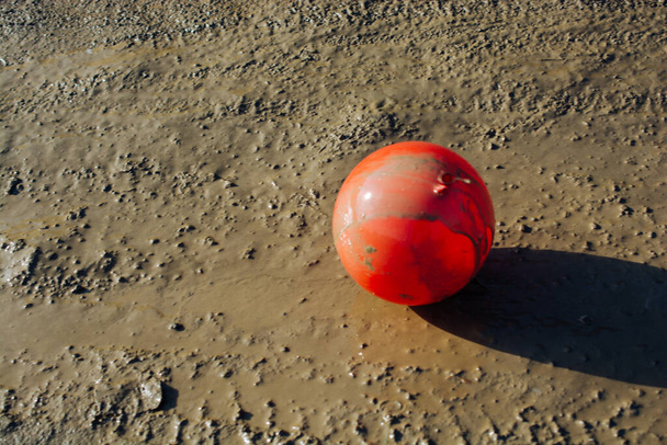 Ballon coloré au sol recouvert de boue - Photo, image