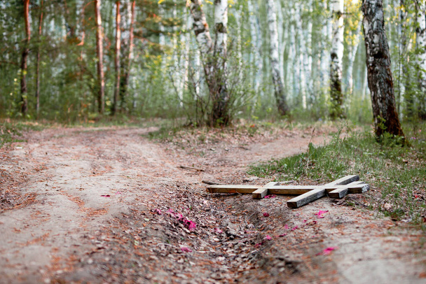 une croix de bois perdue lors des funérailles est couchée sur la route. Croix orthodoxe se trouve sur la route - Photo, image