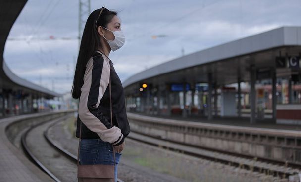 Young Asian woman at a railway station waiting for the train - urban photography - Фото, изображение