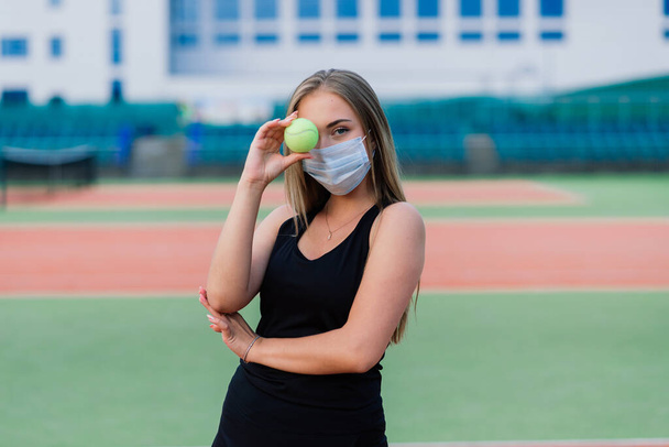 Female tennis player playing with protective mask on court - Foto, Imagem