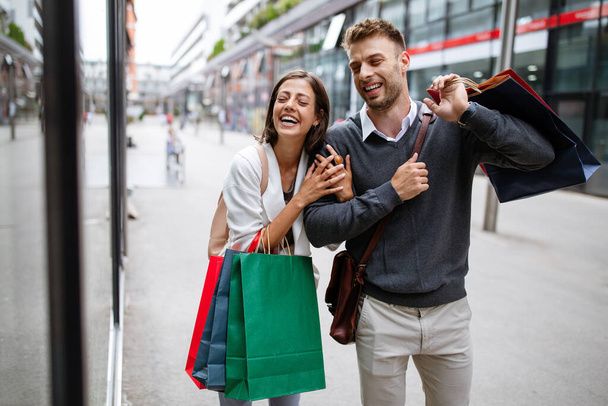 Happy young couple with shopping bags. Sale, travel, love consumerism and people concept. - Fotografie, Obrázek