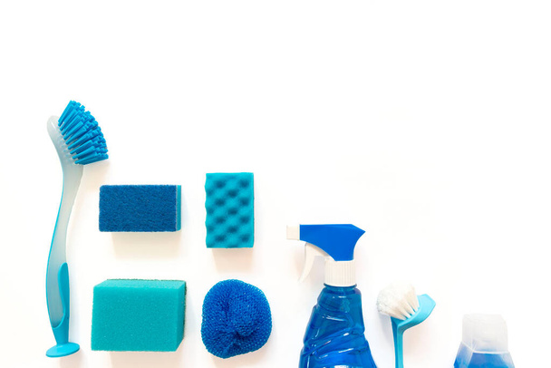 Blue cleaning kit. Bottles, spray, brushes, sponges flat lay on the white background with copy space - Foto, Bild