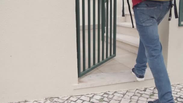 Deliveryman ανοίγει τις πύλες, αφήνοντας πακέτα στις σκάλες των πελατών - Πλάνα, βίντεο