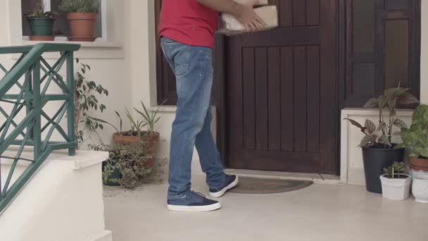 Courier αφήνοντας πακέτα στην πόρτα των πελατών - Πλάνα, βίντεο