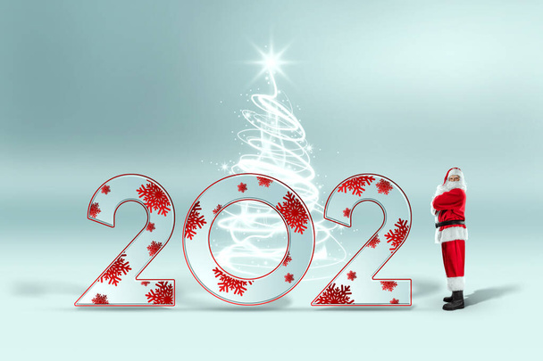 赤いスーツと番号2021年の完全な成長でサンタクロースの肖像画、光の背景。クリスマスの前夜、休暇、休日のバナー、新年のコンセプト - 写真・画像